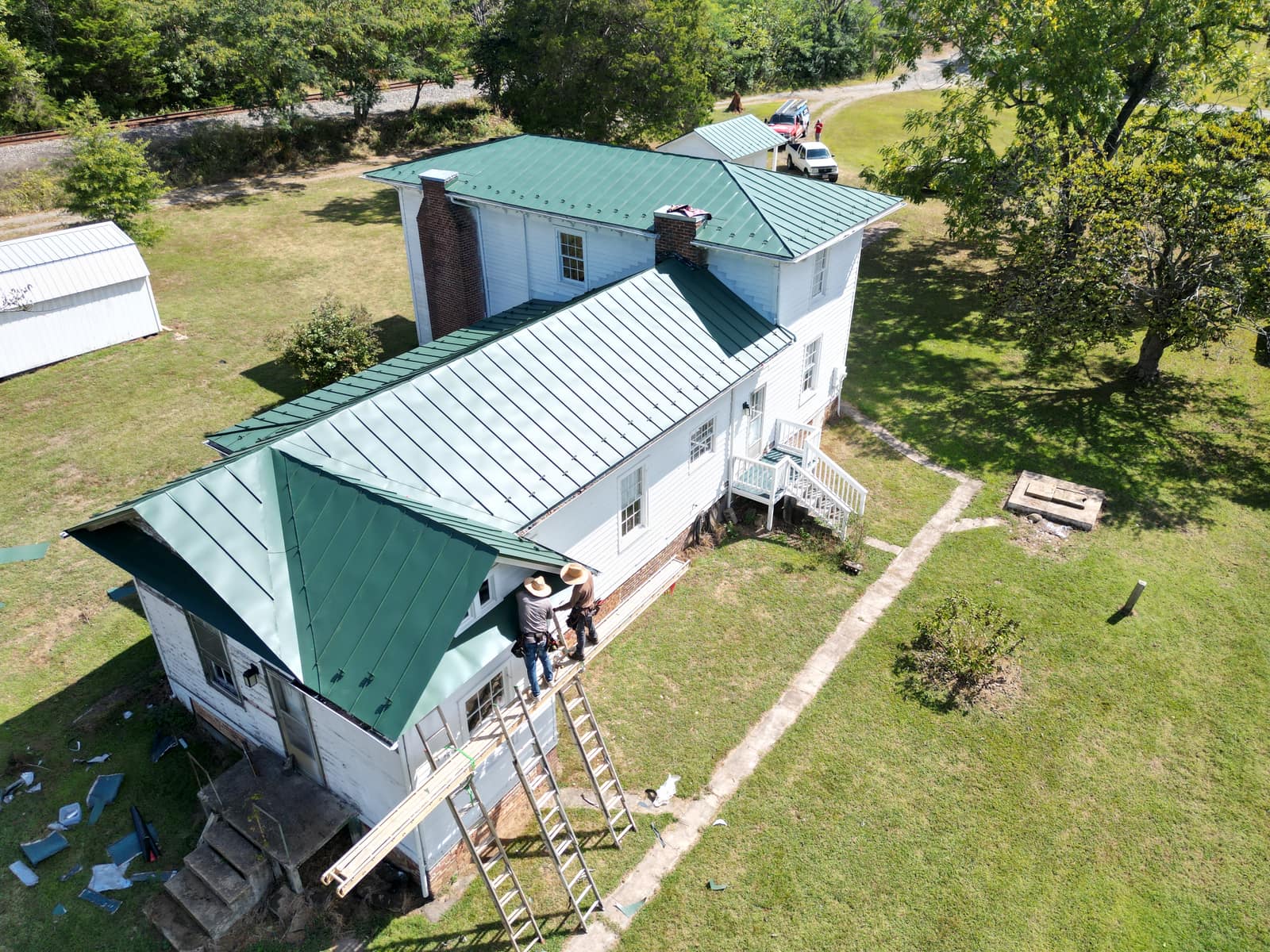 Historic Scottsville-area farmhouse mid-installation of a green standing-seam metal roof by Lounsbury Roofing