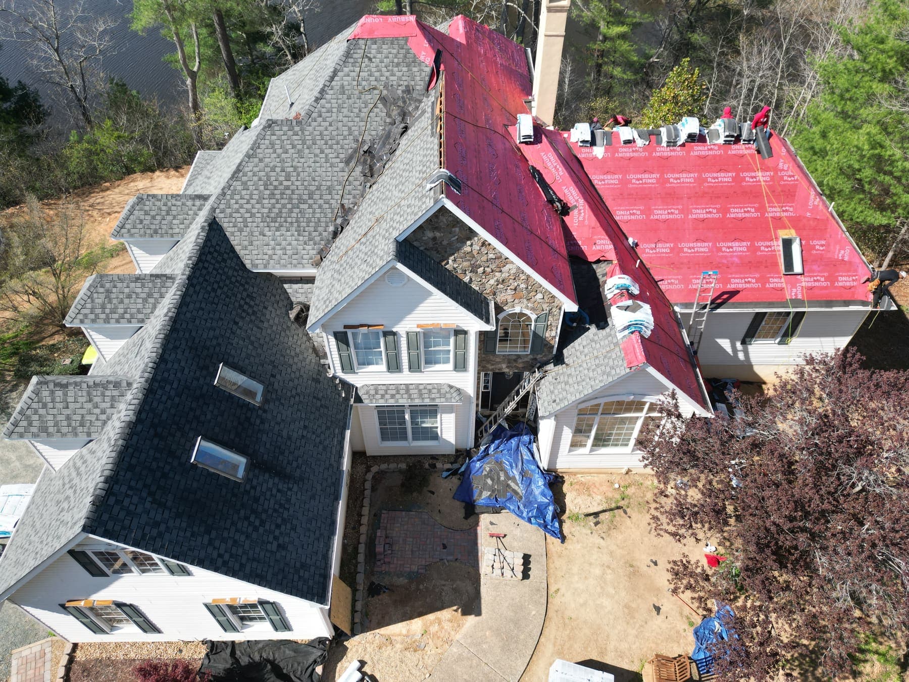 Aerial of a large estate mid-reroof with red underlayment by Lounsbury Roofing
